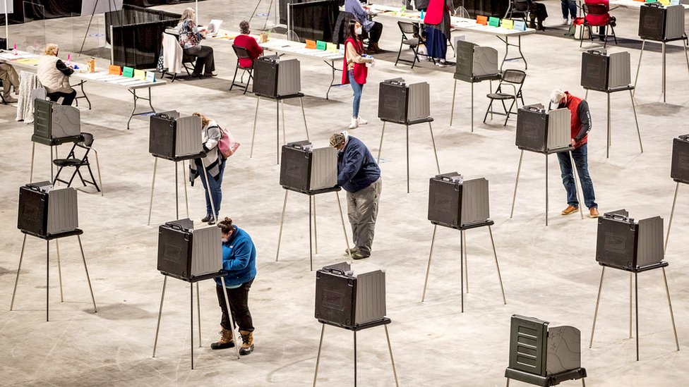 Voters fill out and cast their ballots at the Cross Insurance Center polling location in Bangor, Maine