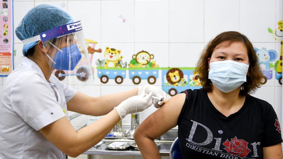 A woman receives a vaccine as Vietnam starts its official rollout of AstraZeneca's coronavirus disease