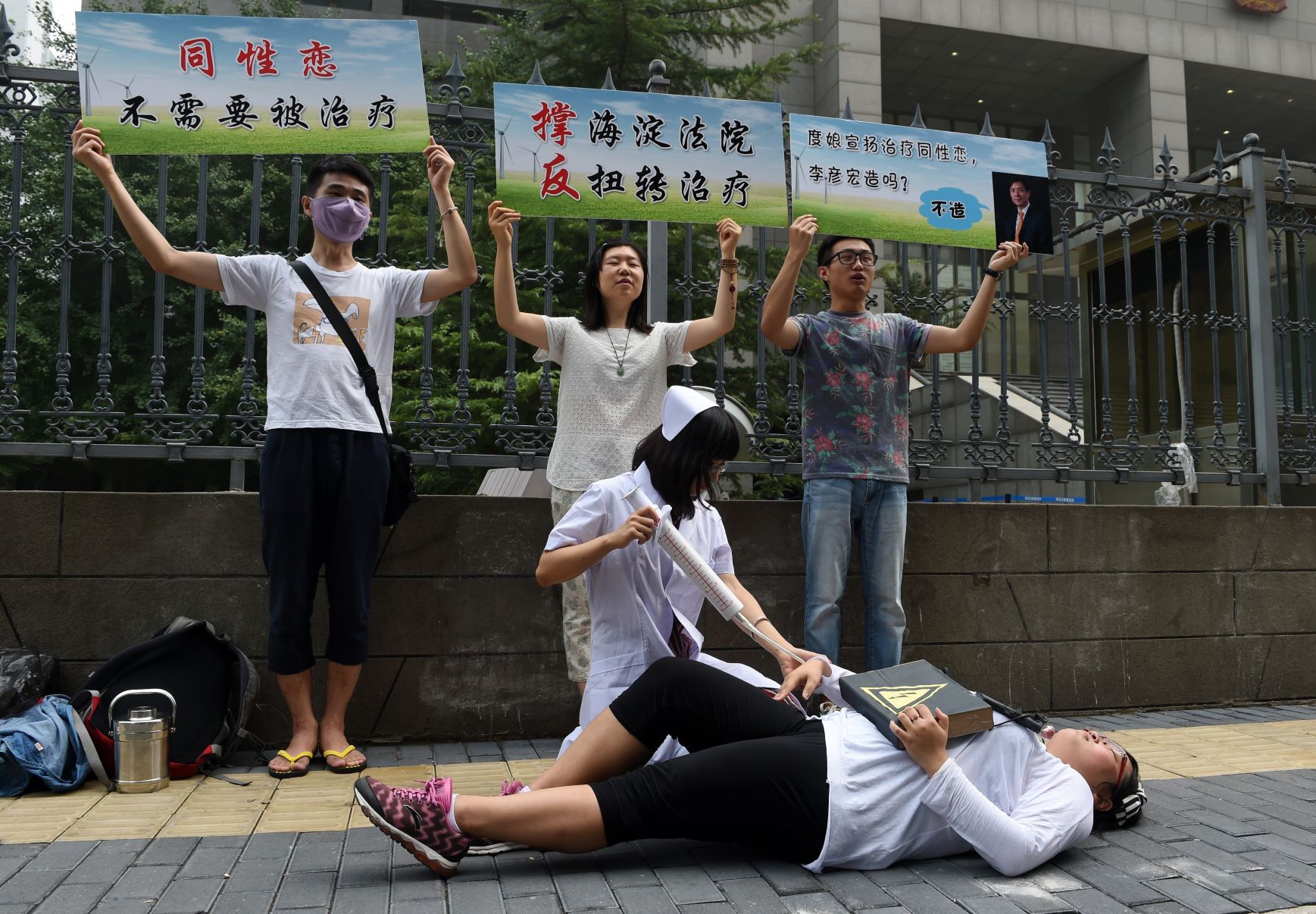 Xiao Tie, executive director of the Beijing LGBT Centre, pretends to inject a patient with a mock syringe during a protest outside the Haidian District Court in Beijing on July 31, 2014. The court began hearing a landmark case on 