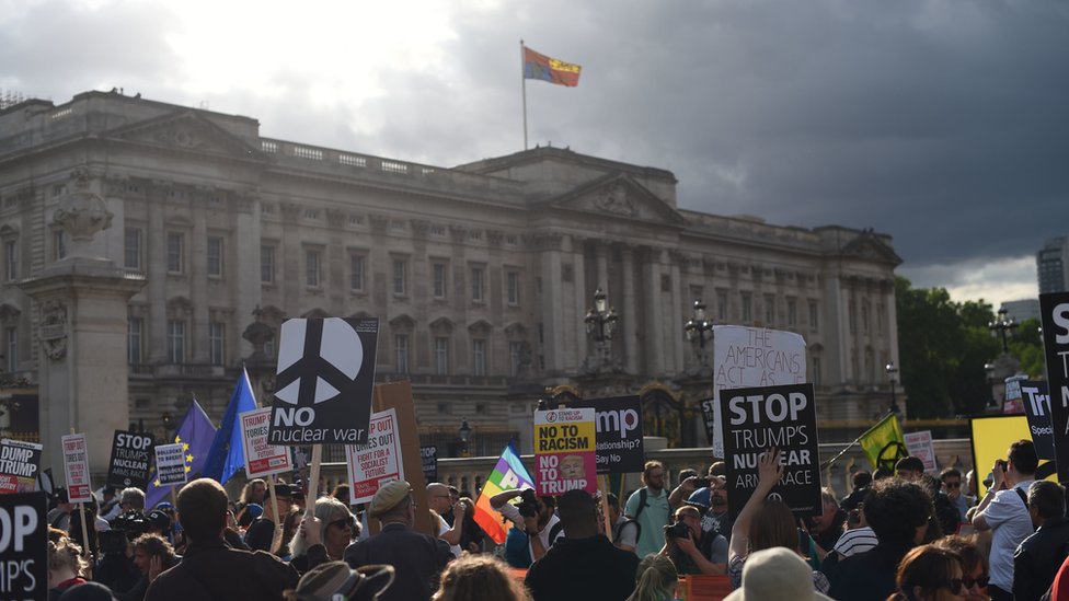 Manifestantes protestando contra Trump afuera del Palacio de Buckingham.