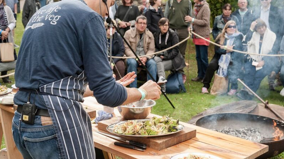 Шеф-повар показывает толпе людей, как готовить на фестивале еды Abergavanny Food Festival 2017.