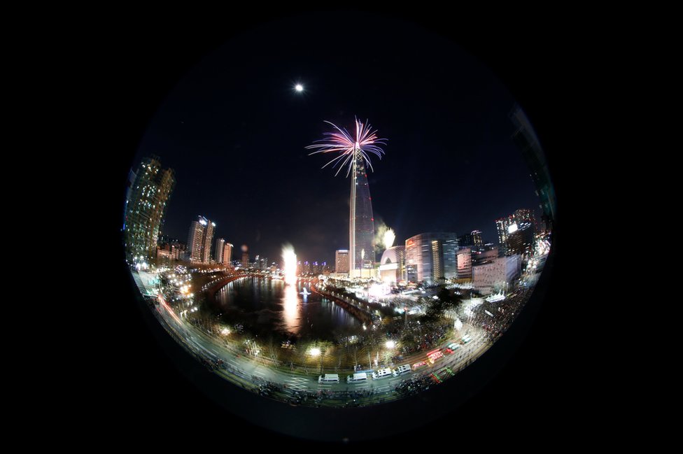 La imagen de las celebraciones en Seúl vistas a través de un objetivo ojo de pez. Resalta la torre Lotte World, de 123 pisos.