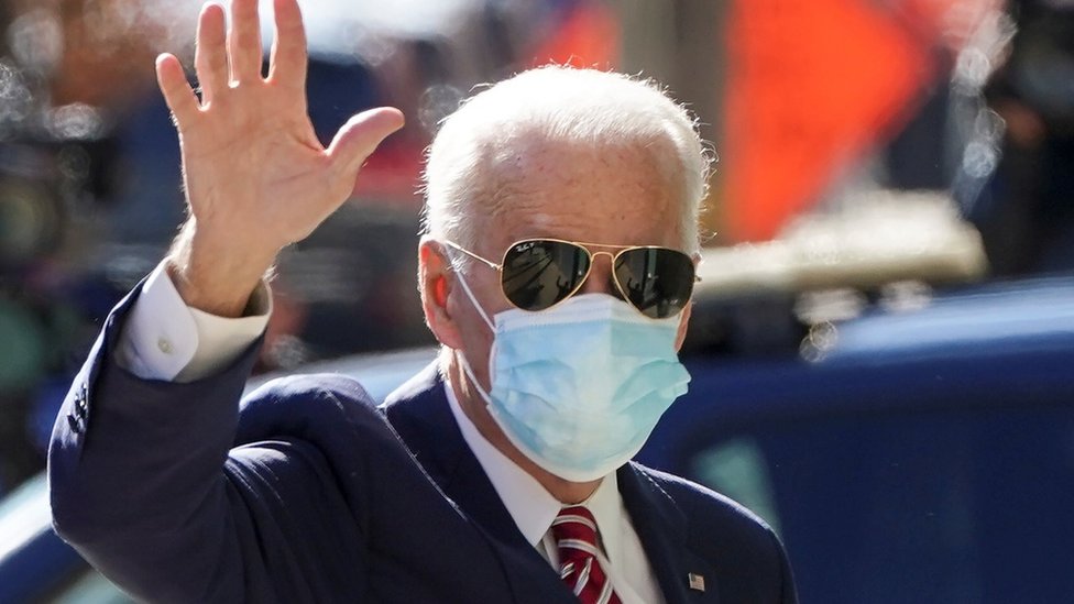Joa Biden usando máscara e óculos escuros