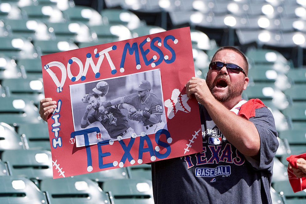 Hombre sostiene un cartel que dice "Don't Mess with Texas" antes del partido entre Toronto Blue Jays at Globe Life Park en Arlington.