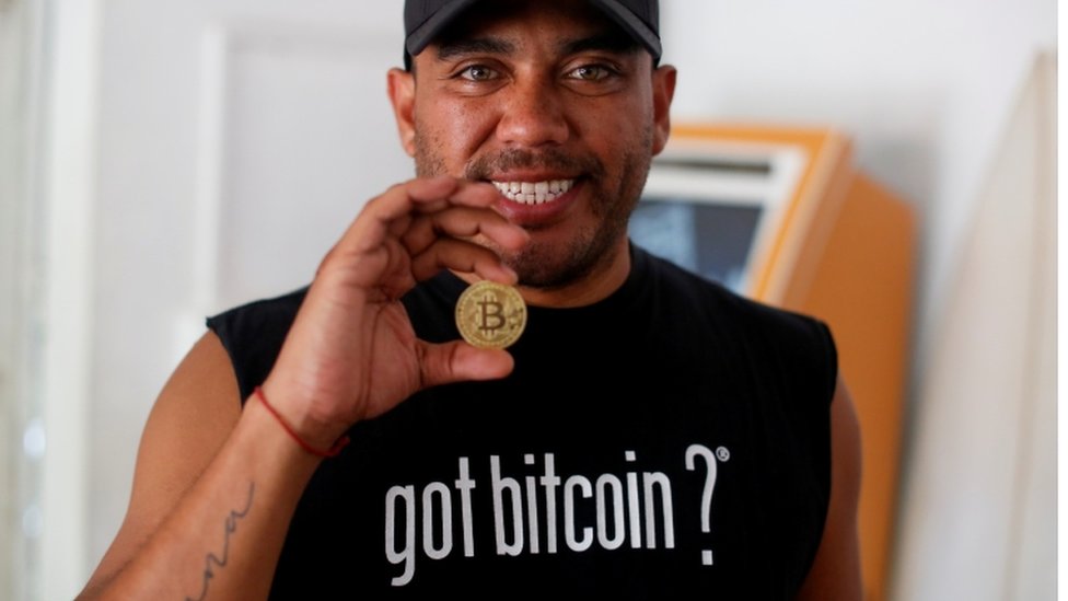 El entusiasta de Bitcoin Carlos Bonilla muestra una representación física de la criptomoneda, en una oficina de soporte de Bitcoin Beach en El Zonte Beach en Chiltiupán, El Salvador.