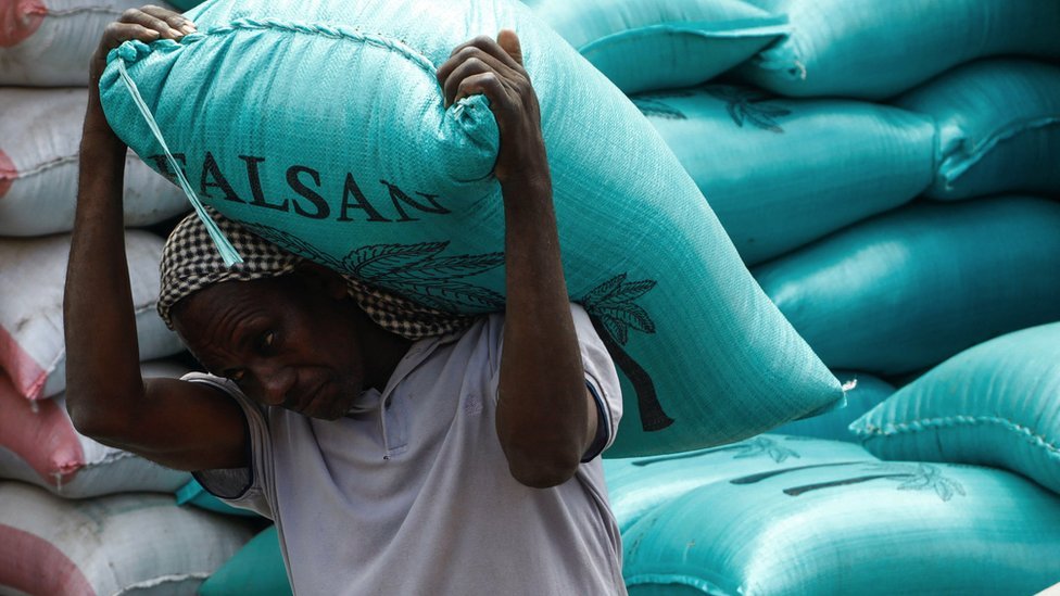 索馬里摩加迪沙巴卡拉市集一位商販抬著一代烏克蘭進口小麥前行（15/7/2023）