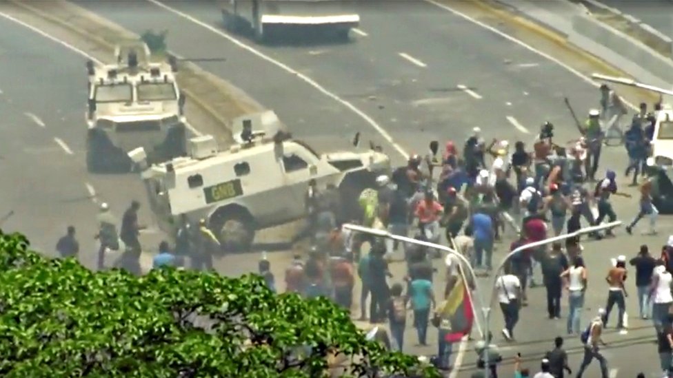 Una tanqueta arremetiendo en contra de manifestantes en Caracas.