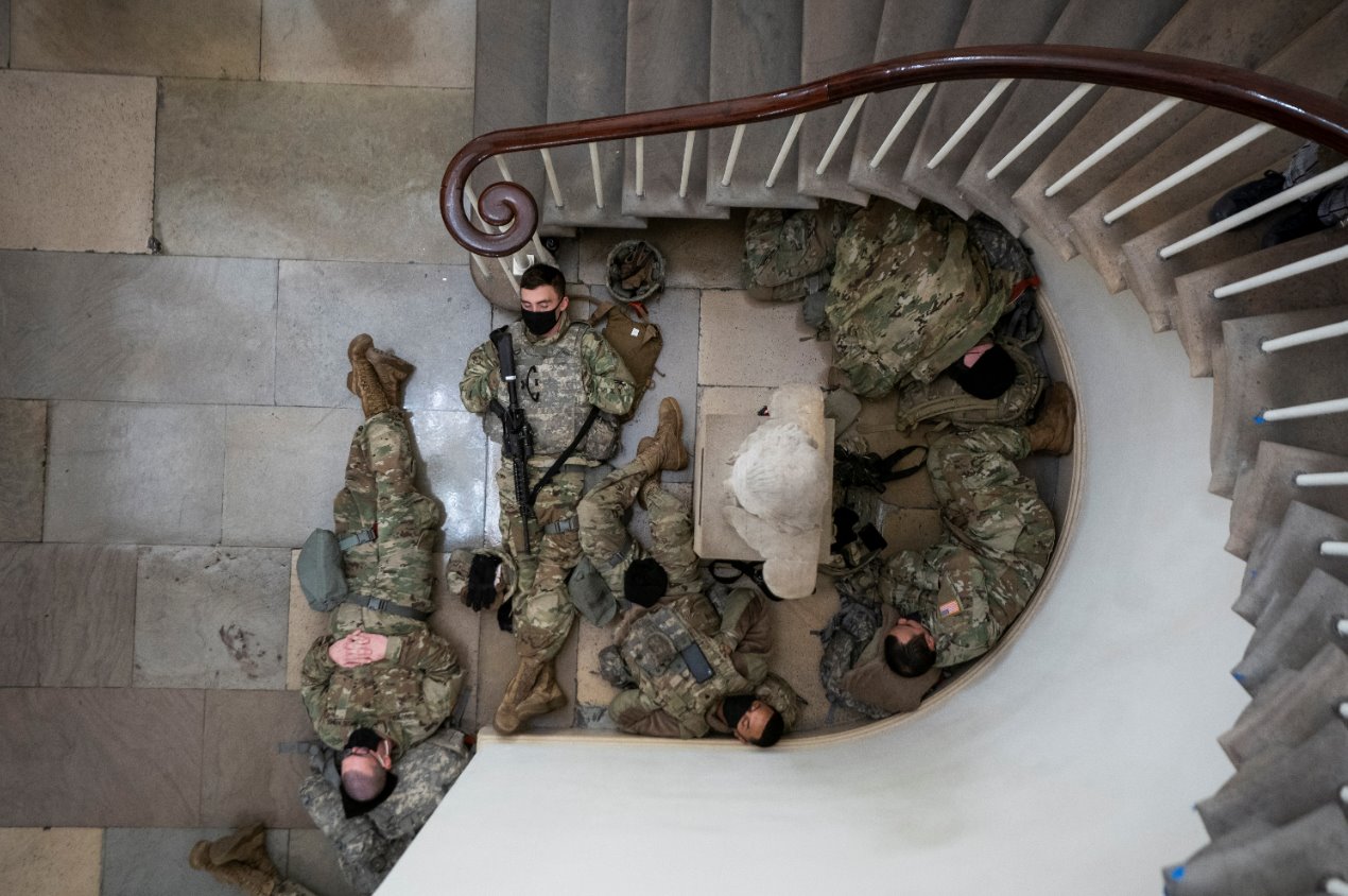 Downward view shows Guardsmen resting by a stairwell