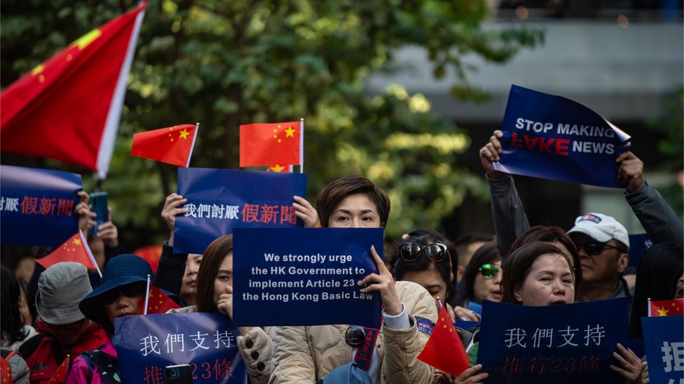 香港灣仔某親政府示威上一群女示威者舉起「討厭假新聞」、「支持二十三條立法」等標語與中國國旗（7/12/2019）