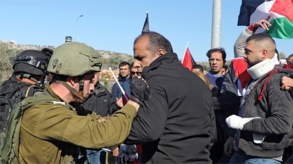 جندي إسرائيلي ومواطن فلسطيني