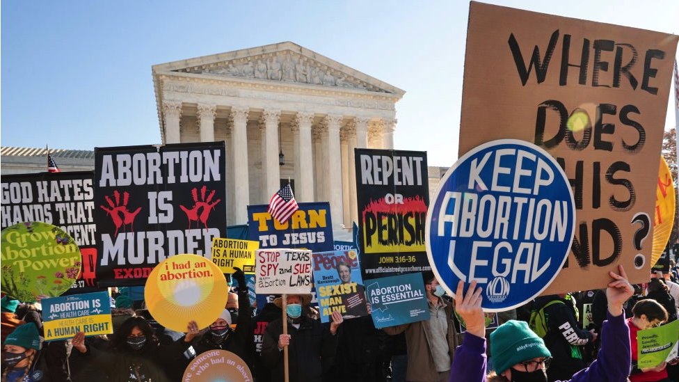 Placards showing opposing views on abortion are displayed in a 2021 demonstration in front of the US Supreme Court in Washington