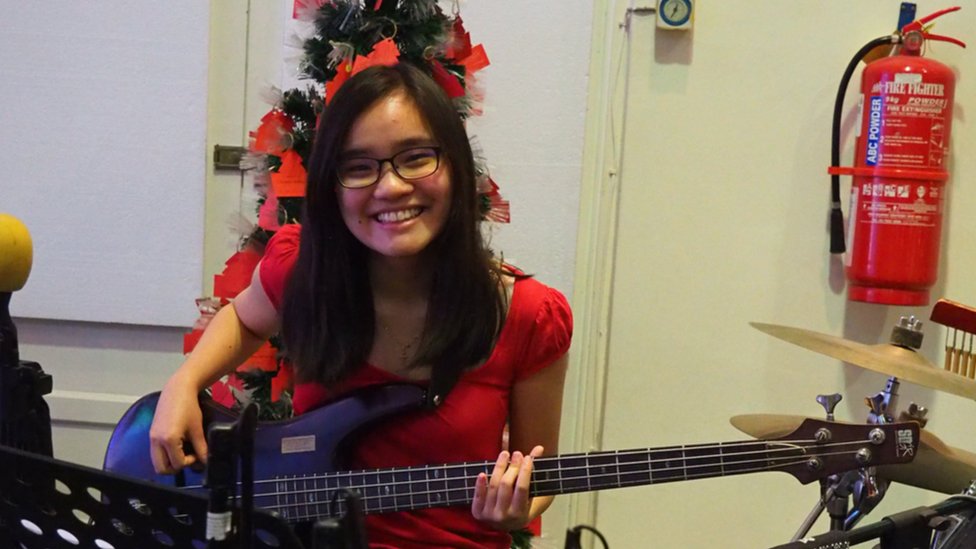 Эмили Хо практикует бас-гитару на рождественской службе