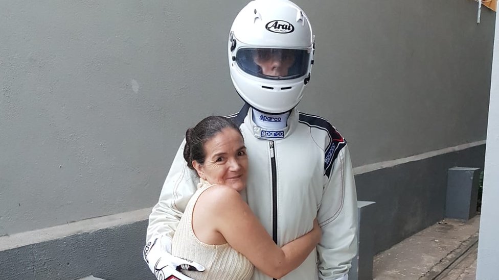 Branca posa abraçada de Dimy, que está com um capacete antes de corrida