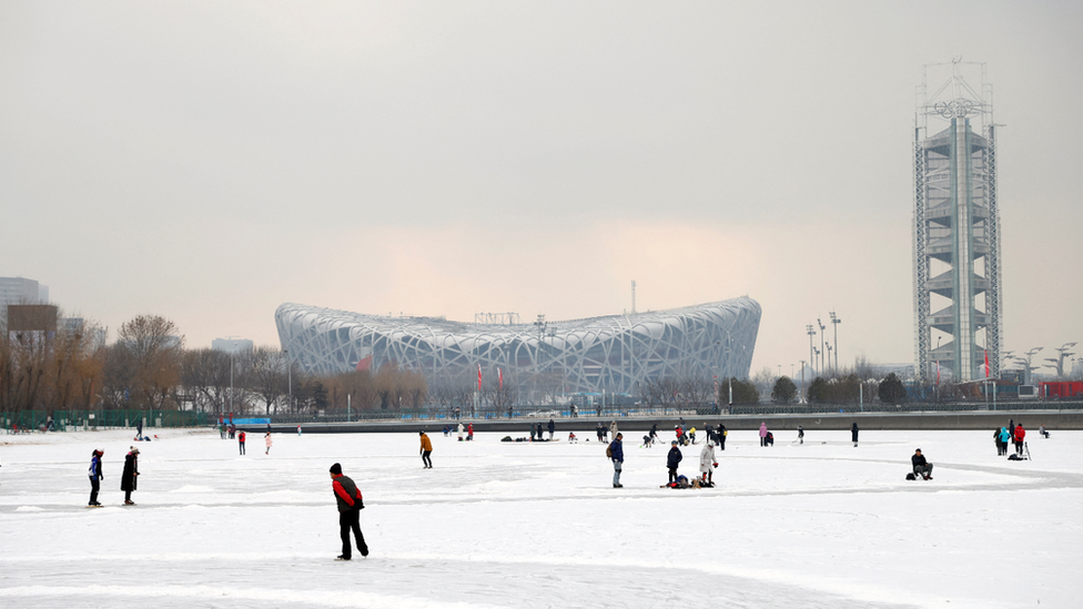 People skate on the frozen canal in front of the Birds Nest national stadium in Beijing in January 2022