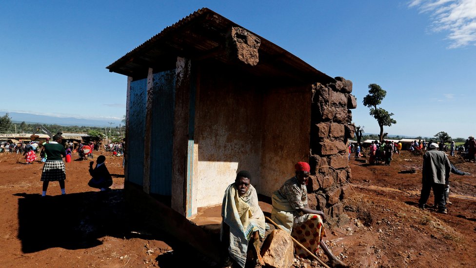 Выжившие сидят возле своего разрушенного дома после прорыва дамбы, в результате чего вода пролила воду в соседних домах в городе Солио недалеко от Накуру, Кения, 10 мая 2018 г.