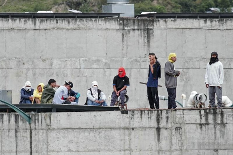 Prison inmates stand guard on a roof