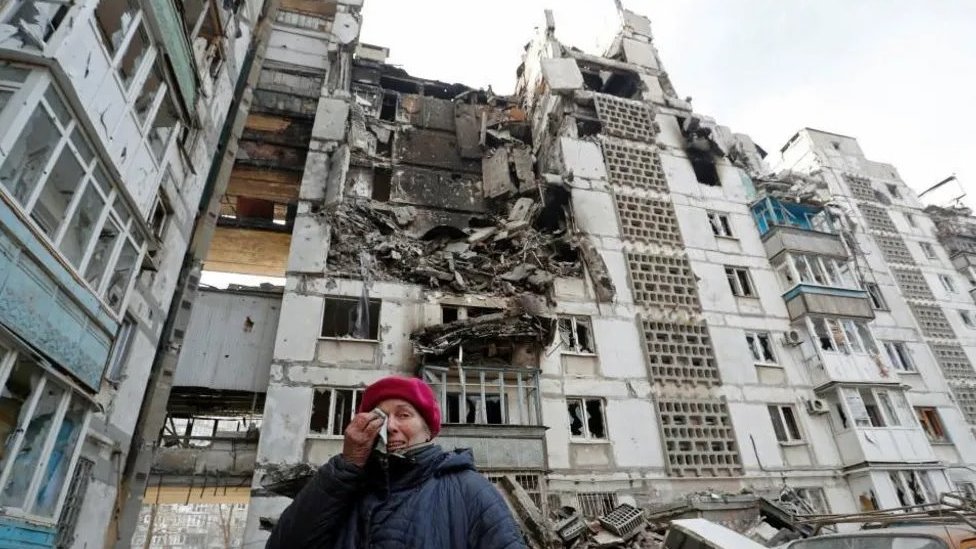 Žena plače ispred srušene zgrade