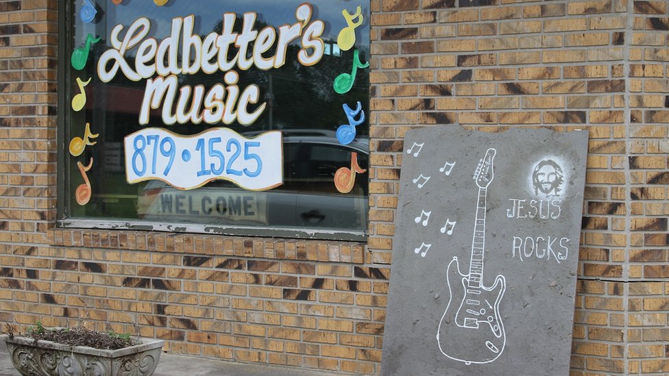 Aquí la religión "dicta el estilo de vida y la política", dicen las voces más críticas del pueblo. Cartel de "Jesus rocks" frente a una tienda de música en Jamestown