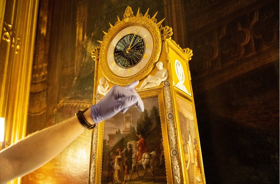 Fjodor points to a beautiful clock that features cherubs and panel paintings