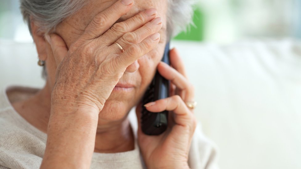 пожилая, обеспокоенная женщина разговаривает по телефону