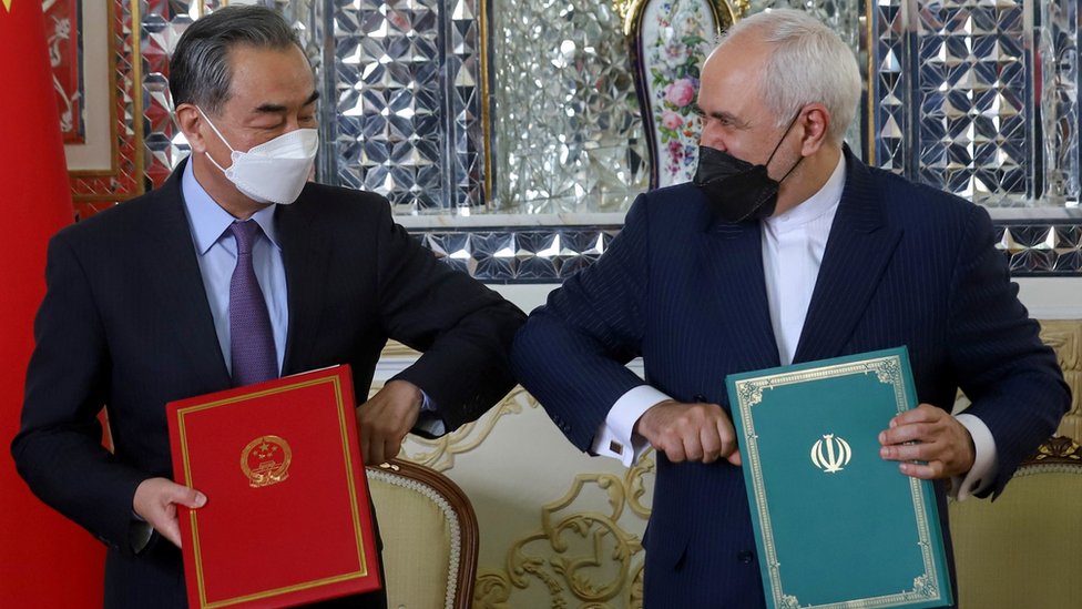 Iran"s Foreign Minister Mohammad Javad Zarif and China"s Foreign Minister Wang Yi bump elbows during the signing ceremony of a 25-year cooperation agreement, in Tehran, Iran March 27, 2021.