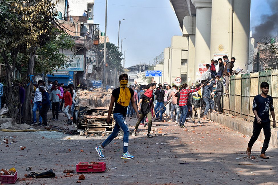 Протестующие, замеченные во время столкновений между группой протестующих против CAA и сторонниками нового закона о гражданстве, возле станций метро Maujpur и Jaffrabad 24 февраля 2020 года в Нью-Дели