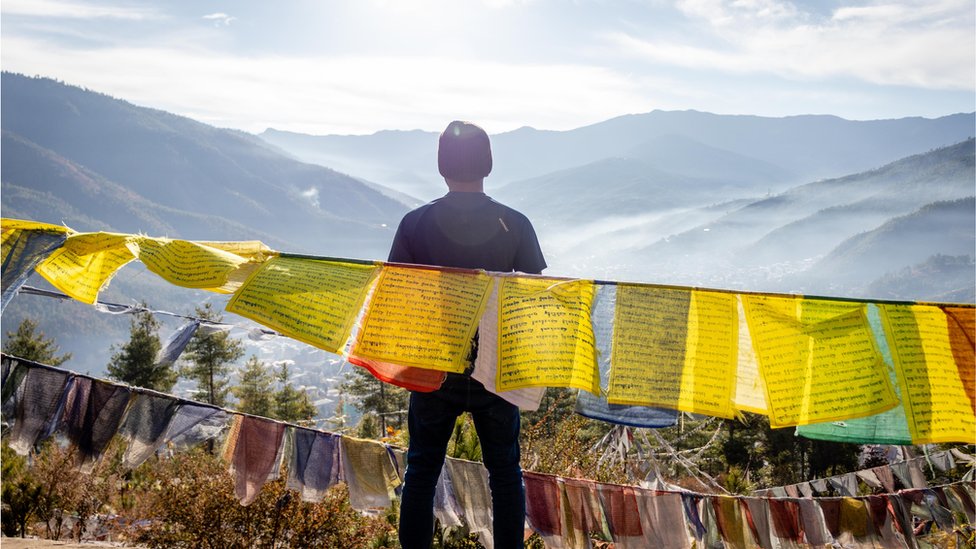 رجل ينظر إلى جبال بوتان