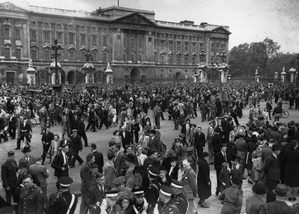 Uma multidão se reúne do lado de fora do Palácio de Buckingham no Dia da Vitória, 8 de maio de 1945.