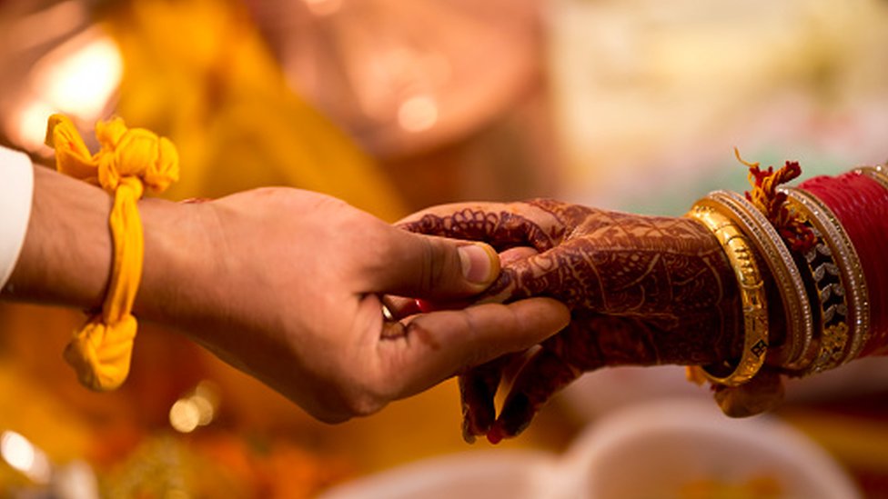印度新娘和新郎在婚禮上手牽手。