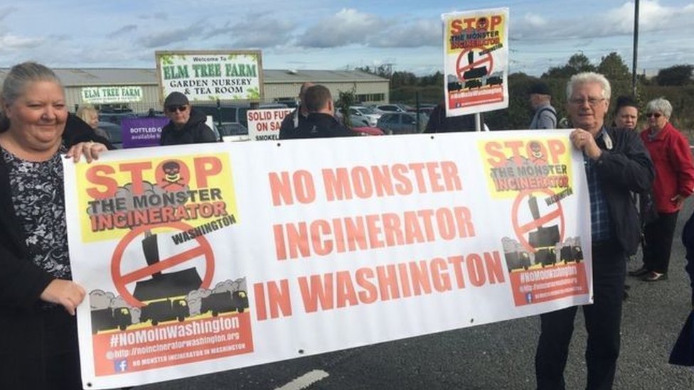 Участники кампании против мусоросжигательного завода с табличкой: «В Вашингтоне нет мусоросжигательного завода»