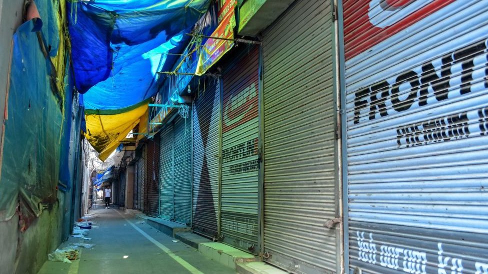 Мужчина проходит мимо закрытых магазинов во время остановки в Сринагаре, Кашмир.