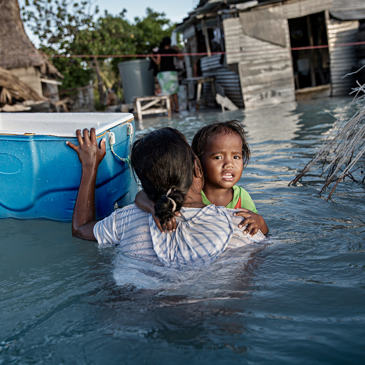 A woman and child in floodwaters on the Pacific island of Kiribati