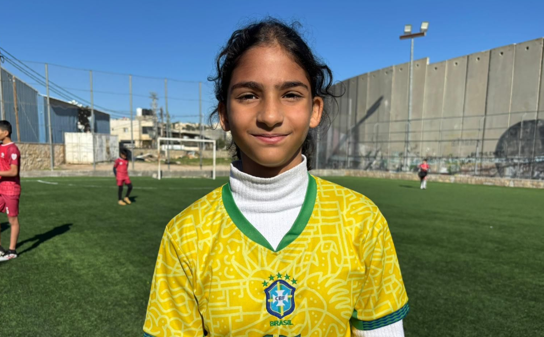 Naya is a ten year old Palestinian girl wearing a Brazil shirt on a football pitch in Bethlehem