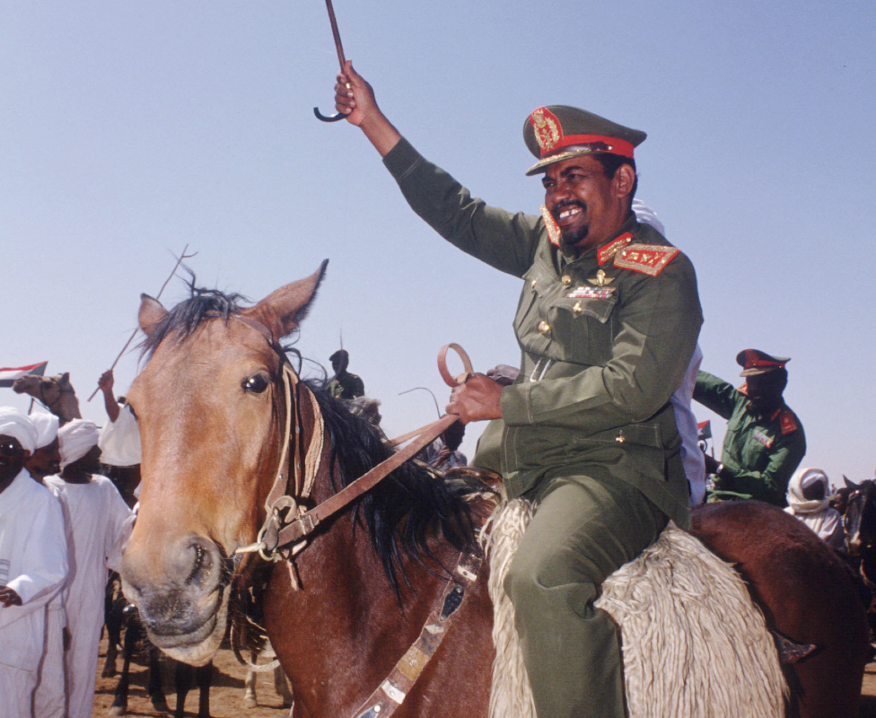 Sudan's Presdent Omar al-Bashir rides a horse greeting supporters in 1992  