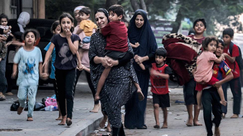 Mujeres y niños abandonando sus hogares por los bombardeos israelíes