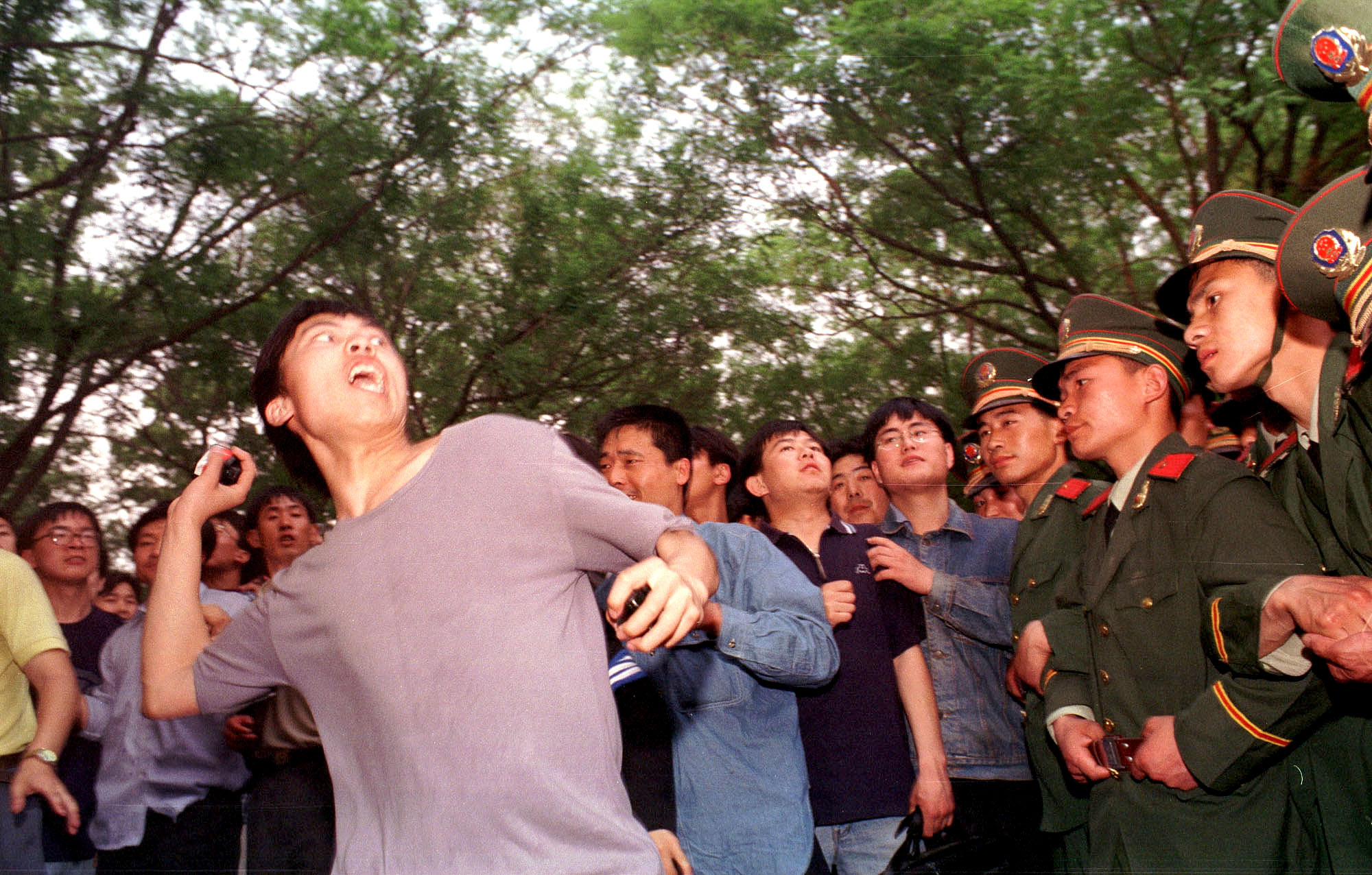 A university student throws a rock during a protest at the U.S. Embassy in Beijing May 9, 1999
