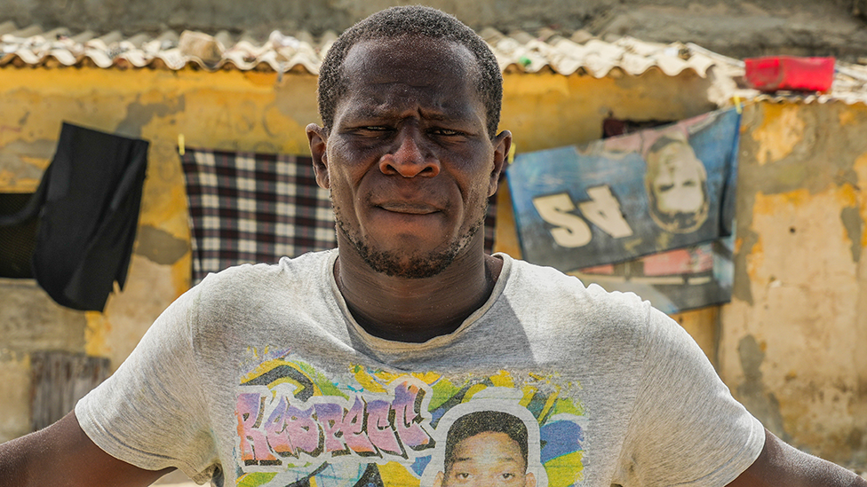 A head and shoulders shot of a man in a grey T-shirt.