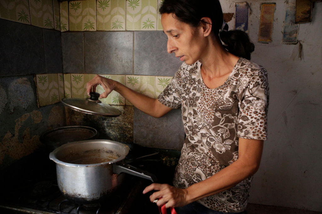 Mujer de bajos recursos cocinando. 