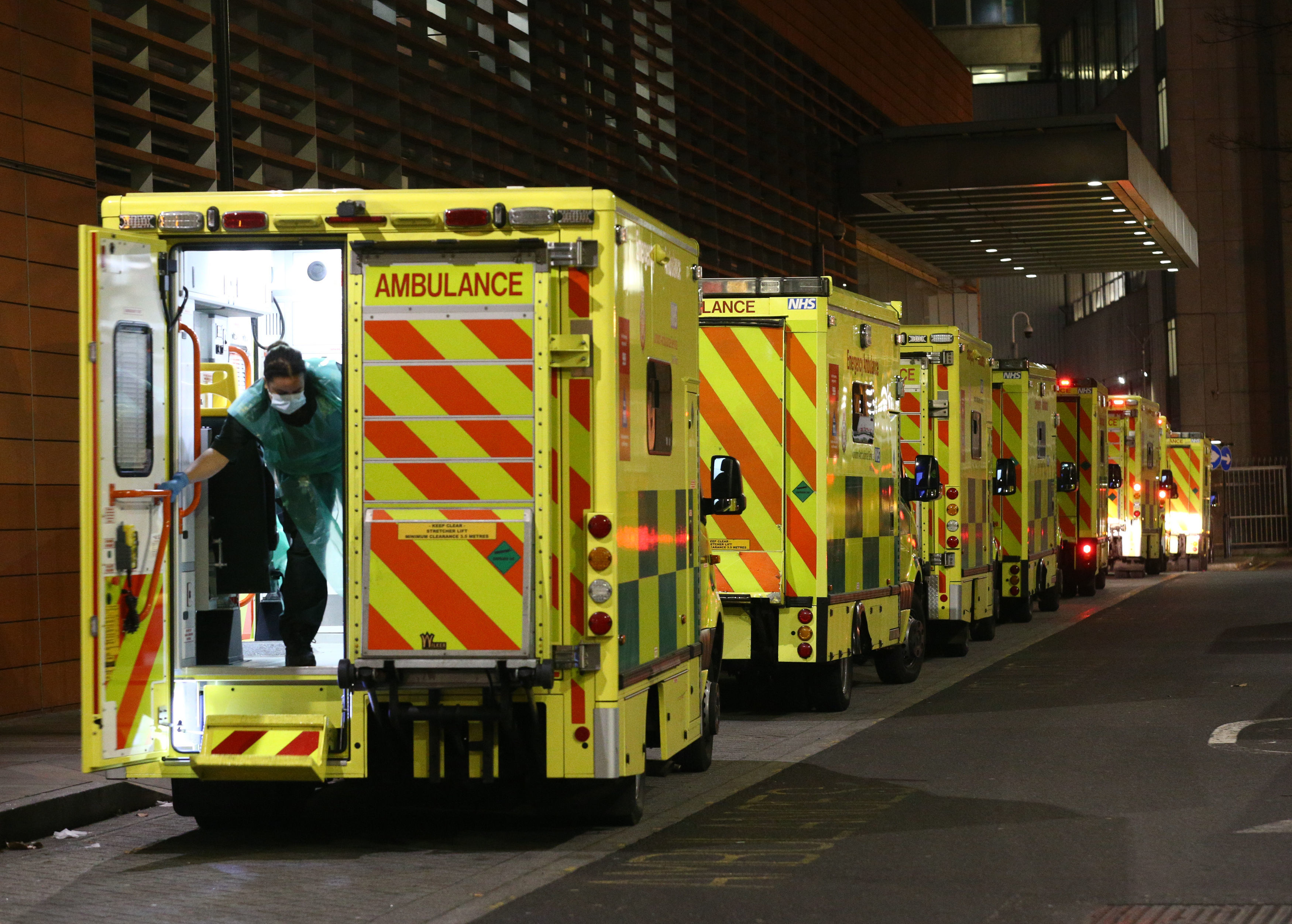 A paramedic opening the rear door of one of the ambulances queued outside the Royal London Hospital