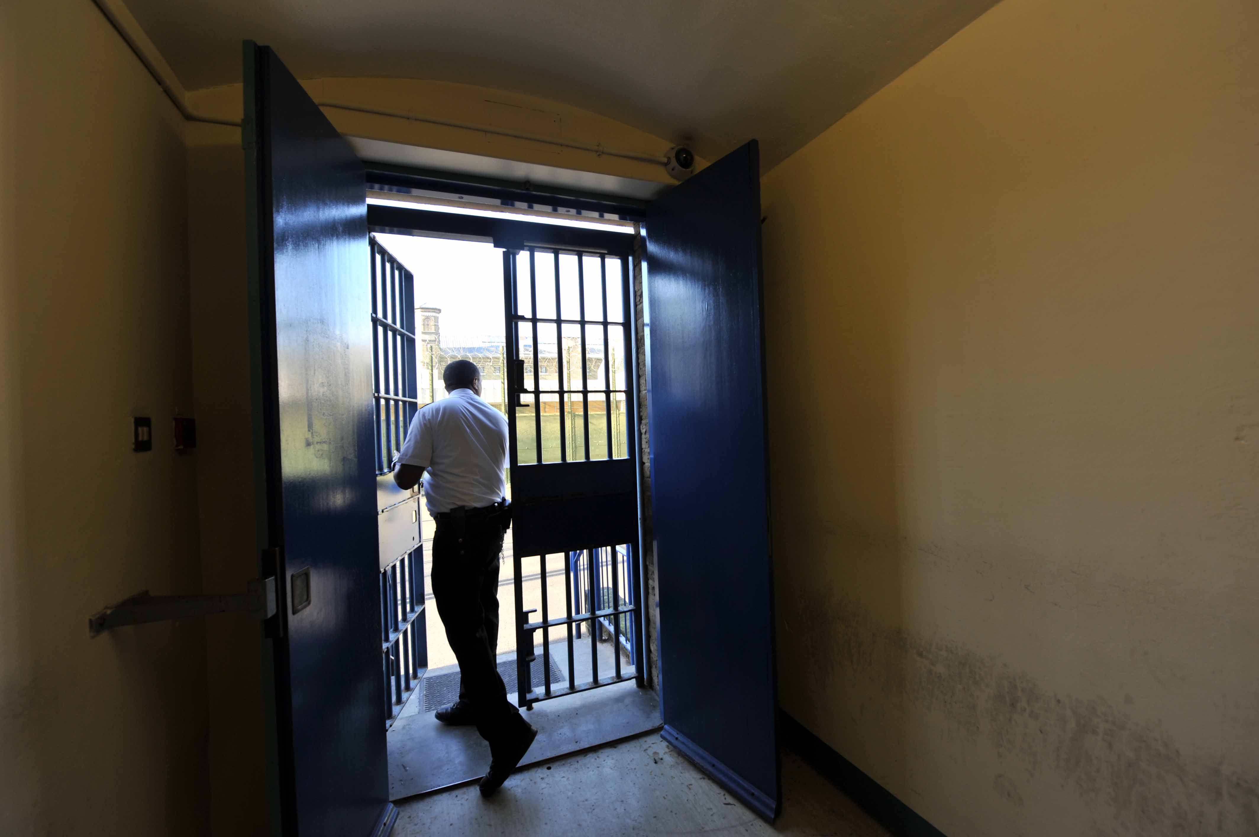 prison officer at Wormwood Scrubs opening a door