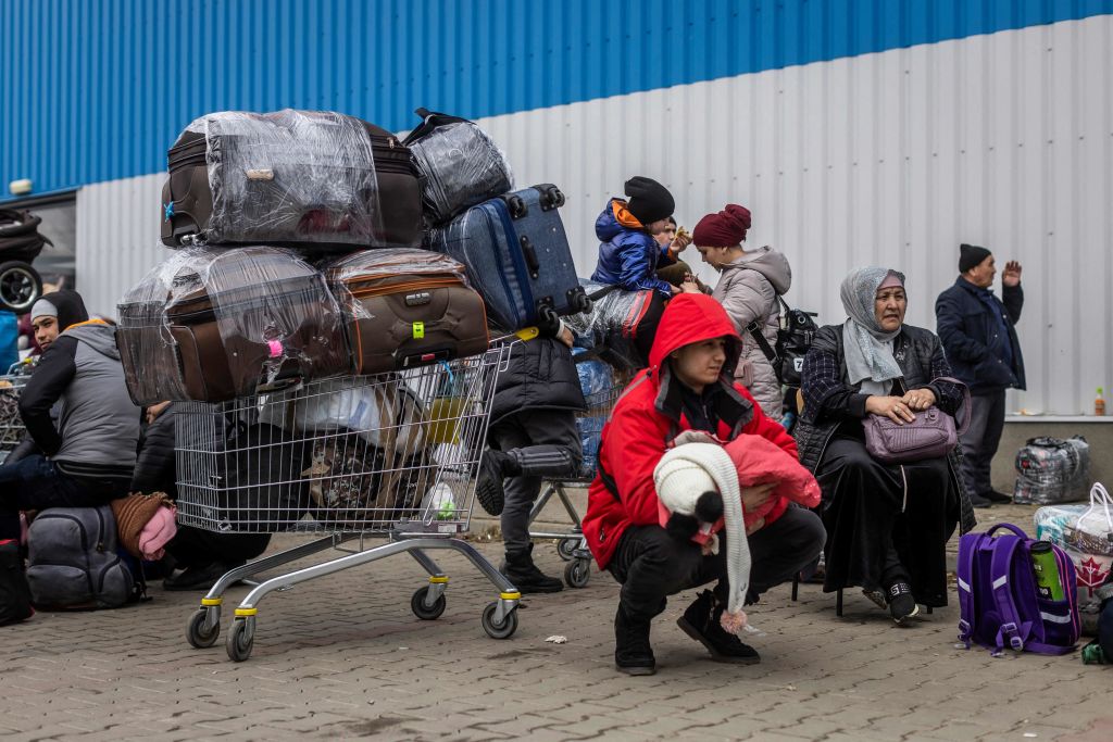 A family from Uzbekistan sits outside a Temporary Reception Centre in Korczowa, on March 02, 2022.