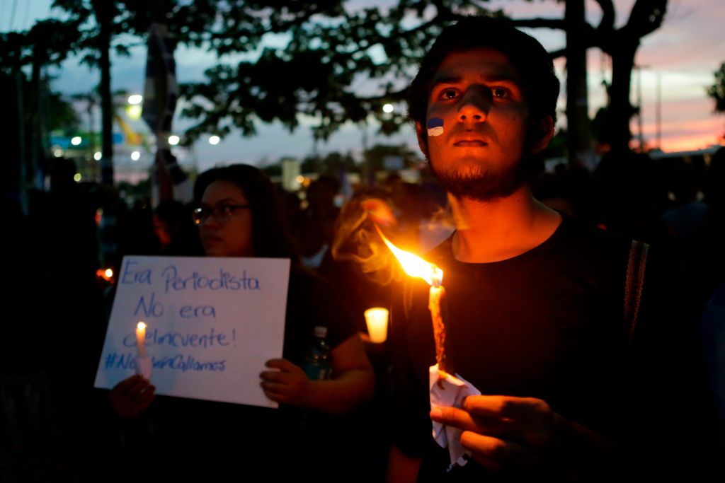 Un hombre con una vela en medio de una protesta en Nicaragua. 