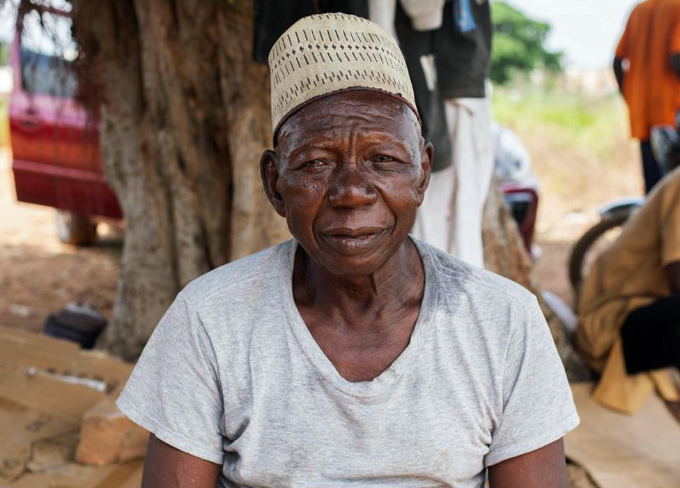 An elderly man wearing a traditional nigerian hat