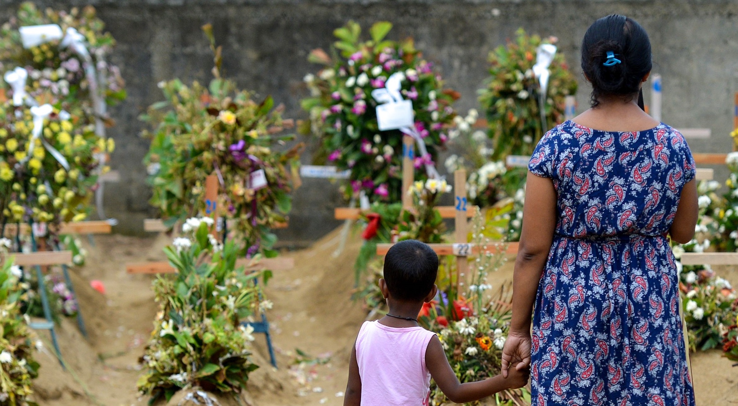 Relatives pay their respects in front of the graves of the victims of recent bomb blasts at St. Sebastian's Church in Negombo on April 28, 2019, a week after a series of bomb blast