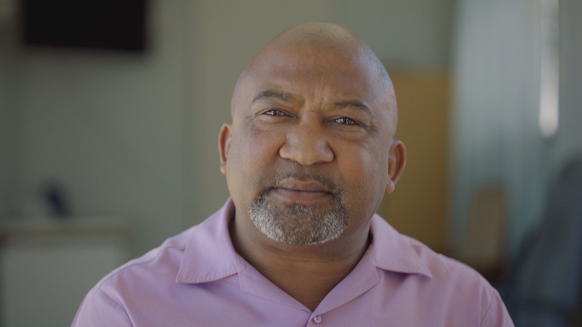 A man in a pink short looking at the camera.