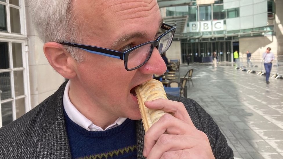 James Gallagher eating a vegan sausage roll