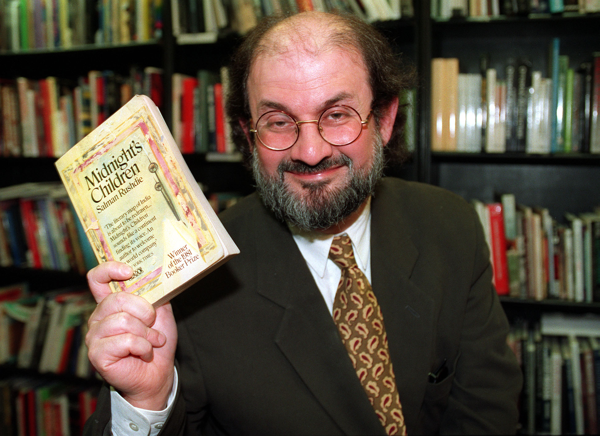 Salman Rushdie holding a copy of Midnight's Childrem