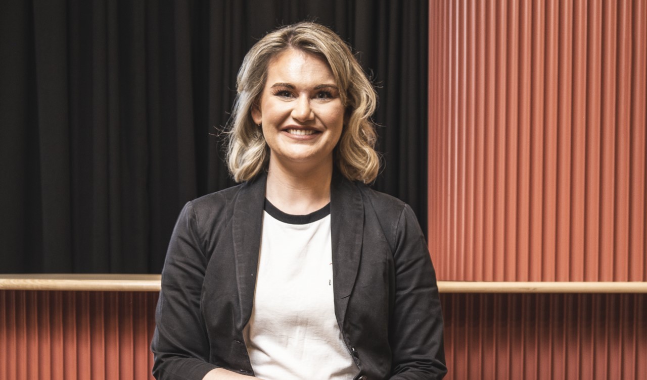 A woman wearing a blazer sitting down