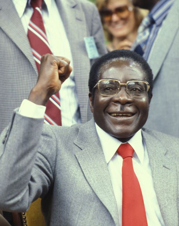 Robert Mugabe  smiles and holds fist in the air, in an image from 1980 