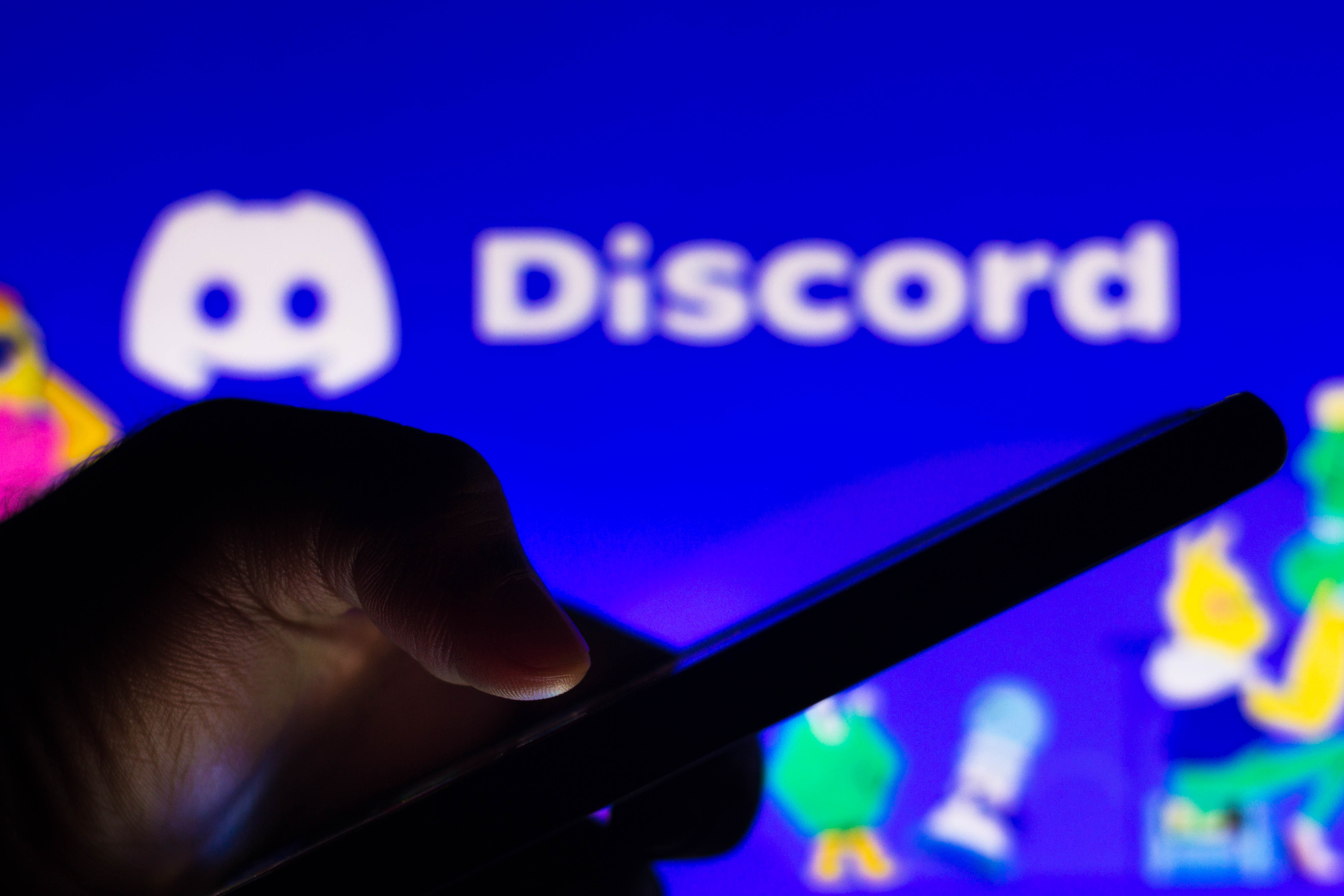  In this photo illustration the PlayStation (PS) logo app seen displayed on a smartphone screen with the logo of Discord in the background